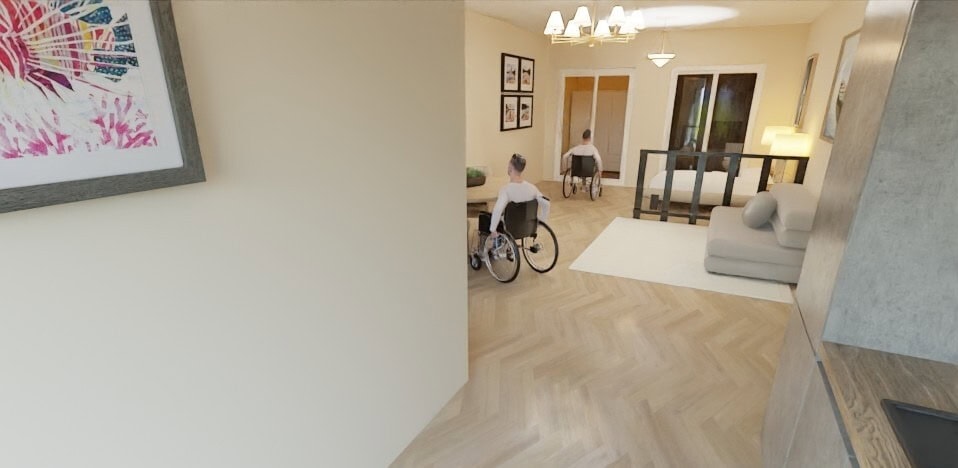 Recreación del interior de la casa donde se ve una persona desplazándose en silla de ruedas